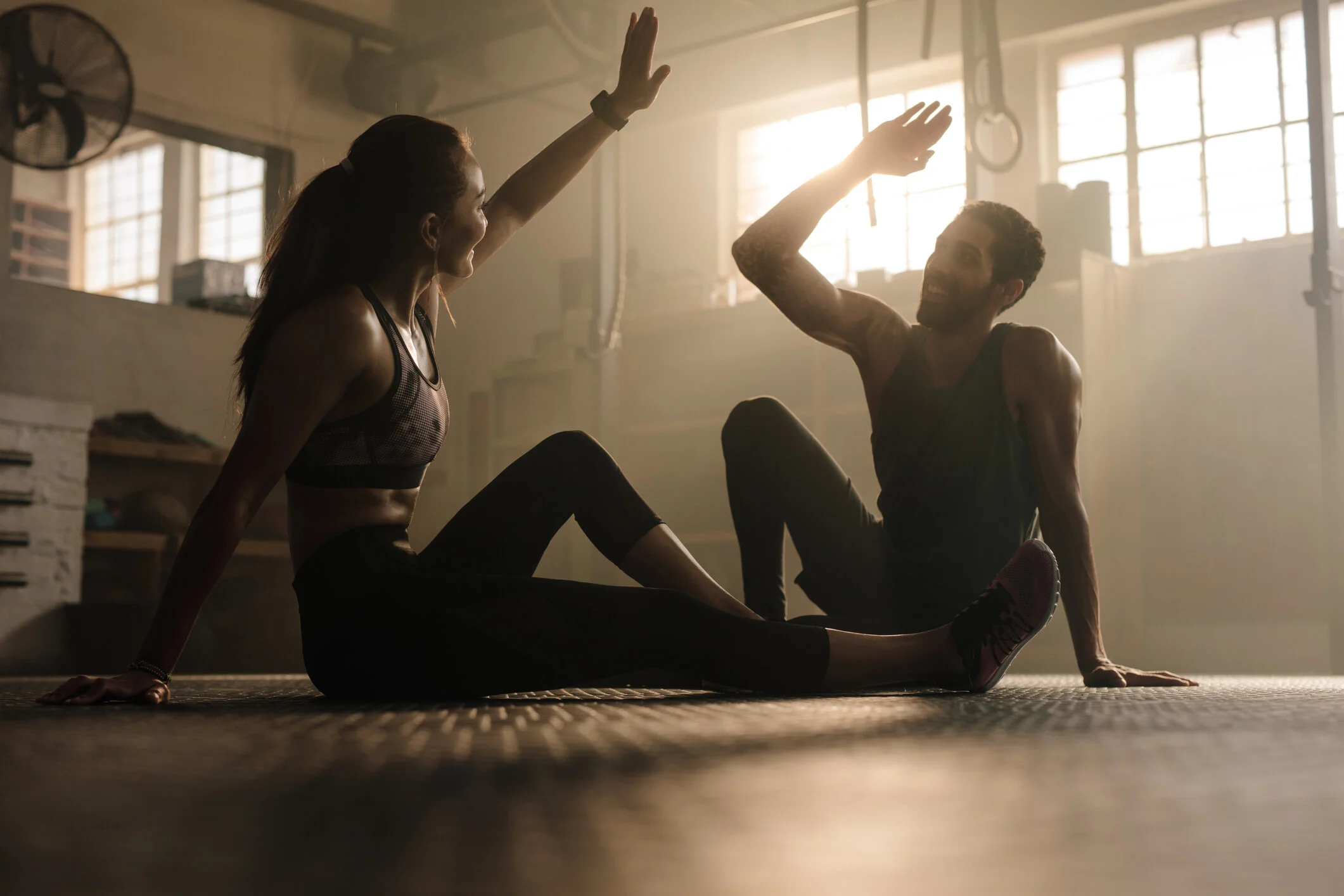 Fitness members giving each other a high-five after completing a workout session at Feel Good Fitness.