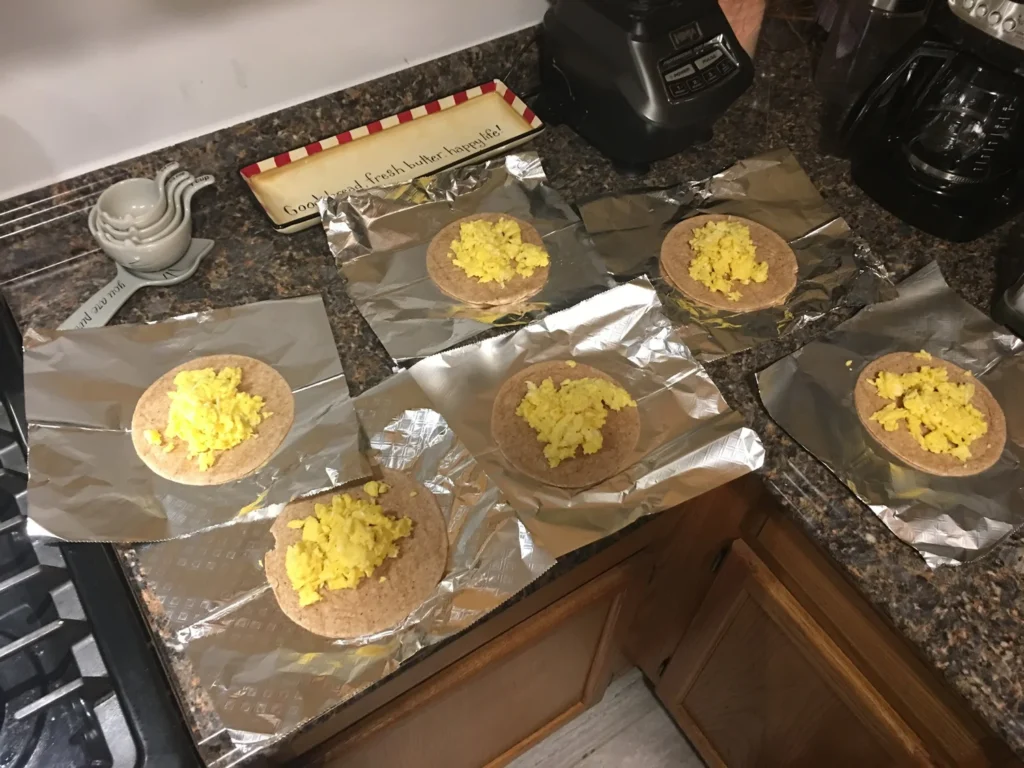 Healthy meal prep of scrambled eggs on wraps, prepared for nutrition clients at Feel Good Fitness.