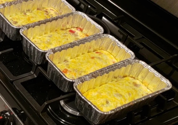 Healthy baked meal prep dishes in foil trays, designed for nutrition clients at Feel Good Fitness.