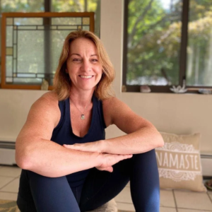 Smiling woman practicing wellness and yoga exercises at home with Feel Good Fitness.